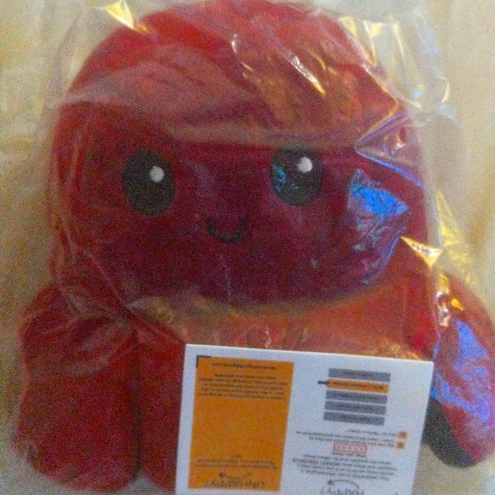 Reversible plushie, red/black colour. With pop it fidget toy.